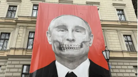 BBC Banner of Russian President Vladimir Putin with 'death mask' on his face, next to the Moscow embassy in Riga, Latvia