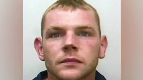 Stephen Wynne, with short blonde hair, looks straight ahead in his police mugshot