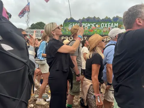 Zoe Ball takes a photo of Pulp, as they play Glastonbury's Pyramid Stage