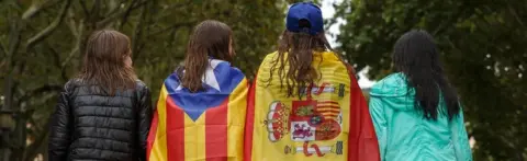 Getty Images Girls stroll through the centre of Figueras with the Spanish and a pro-independence "Estelada" Catalan flag on 30 September 2017