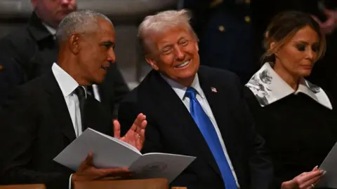 Barack Obama and Donald Trump chat as they wait for Jimmy Carter's funeral to begin.