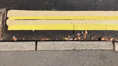 BBC/Seb Cheer Two sets of double yellow lines painted on the same stretch of road, overlapping.