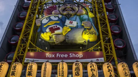 Getty Images Facade outside a Donki store in Japan shows a figure holding the Donpen penguin mascot