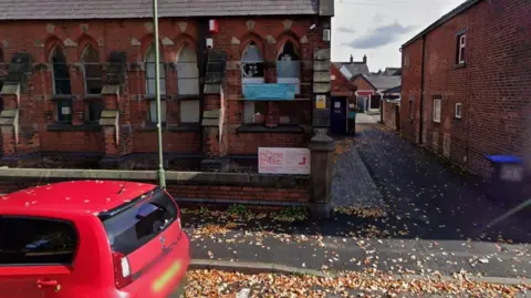 Google A Google street view image showing an old church building with an alleyway next to it. A white sign which says "Home Start" has been mounted on the wall.