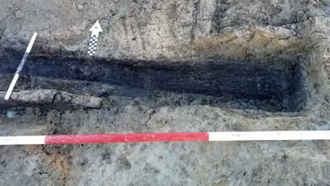 WWHA Coffin Burial, partially excavated, view to the north. 2m and 0.3m scales. 