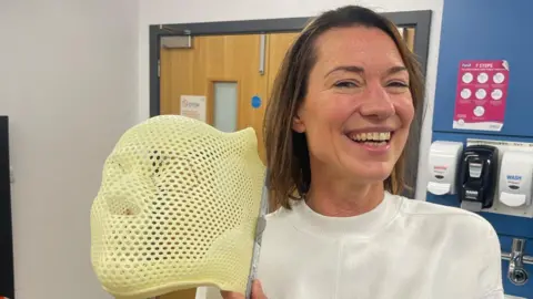 Jo Fuller holding her radiotherapy mask.