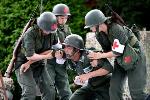Chung Sung-Jun / Getty Images South Korean performers dressed as soldiers participate in a re-enactment
