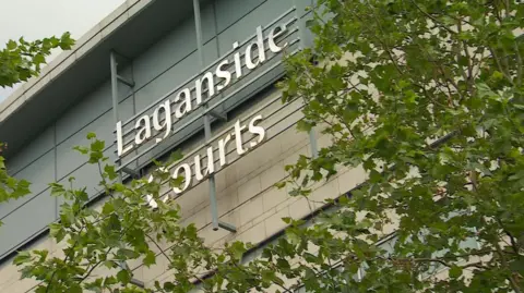 BBC Sign for Laganside courts partially covered by trees