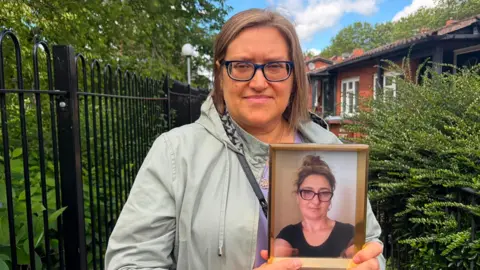 Krystyna Chalastra holding a photo of her late sister