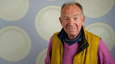 Fantom Events/Paul Phipps-Williams Photography A recent photo of Tom Chadbon smiling against a backdrop that looks like a 1980s Tardis interior