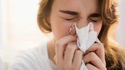 Getty Images Woman blowing her nose