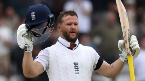 England opener Ben Duckett raises his helmet and bat to celebrate hitting a century