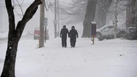 Getty Images A couple makes their way through lake effect snow to attend the annual Hamburg Holiday Parade on November 30, 2024 in Hamburg, New York