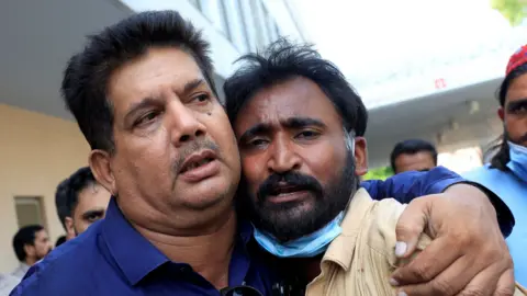 Reuters Samiullah, the father of a newborn who was killed in the PIMS hospital blaze, is comforted.