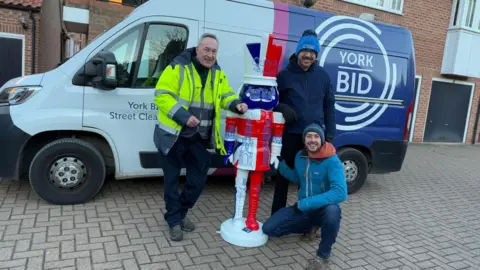 Great Britain-themed Nutcracker statue, decorated with Union Flag, with three people and a York BID-branded van