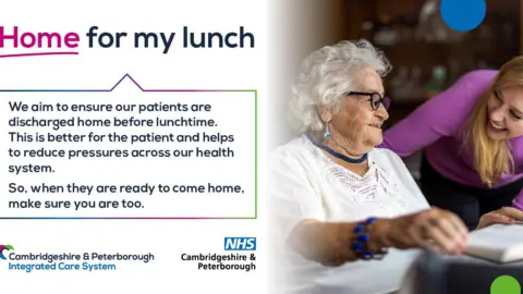 NHS Cambridgeshire and Peterborough A poster with the message "home for my lunch". It includes an elderly woman in a white T-shirt and black framed glasses being comforted by a woman in a purple long-sleeve top. They are both smiling.