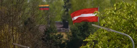 Getty Images Border between Latvia and Lithuania showing the flags of the two countries