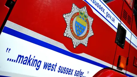 The West Sussex Fire & Rescue Service web address on a red fire engine with a quote saying "... making west sussex safer..."