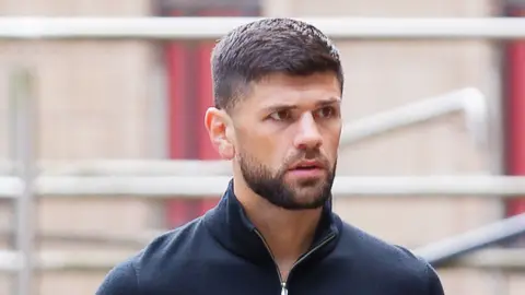 Joe Cordina, a man with brown hair and a brown beard. He's wearing a navy quarter-zip.