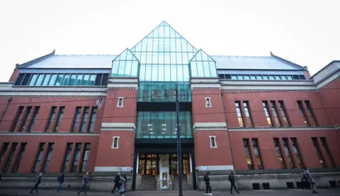 ADAM VAUGHAN/EPA-EFE/REX/Shutterstock Image shows the exterior of Minshull Street Crown Court in Manchester, a modern building with red brick wall and a bottle-green glass central area above the front area. 