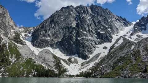 O famoso Aasgard Pass de BBC News/ Max Matza Washington é um passe de montanha coberto de neve com um lago no fundo. 