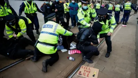 Reuters Police officers detain a demonstrator during a protest in Manchester