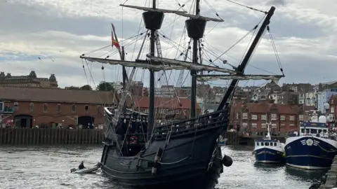 A 16th Century Spanish galleon made of dark wood, with two masts a sails in Scarborough harbour.