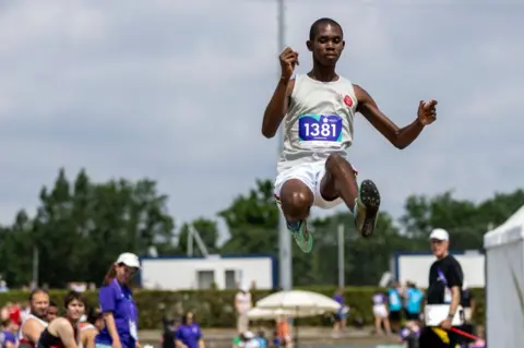 Maja Hitij/AFP Mitchell Prosper of Mauritius competes during Long Jump Level B Men semi-final, during day five of the Special Olympics World Games Berlin 2023.