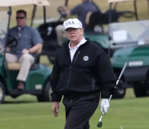 PA Mr Trump plays golf