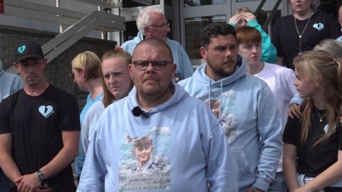 Martin Cosser is seen surrounded by family and supporters outside Brighton Crown Court