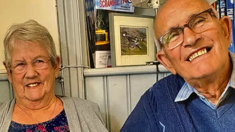 Family picture Valerie and Alan France smile into camera.