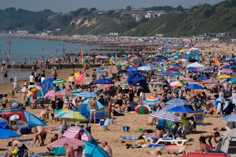 Andrew Matthews/PA Wire A packed Bournemouth beach full of people with parasols
