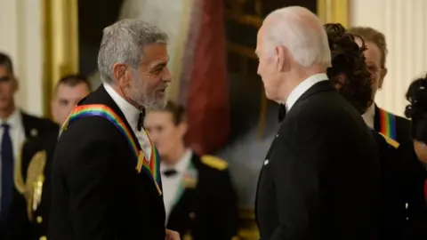 EPA US President Joe Biden (R) greets George Clooney at a reception for Kennedy Center Honorees in the East Room of the White House