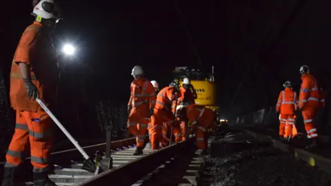 Network Rail Workers in high-vis clothing repairing tracks in the Severn Tunnel