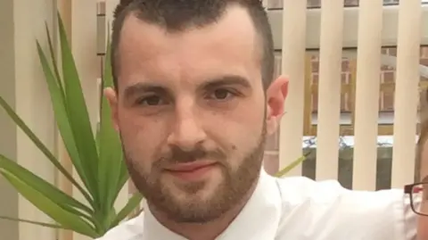 Craig family A head and shoulders shot of a man with short brown hair and stubble.