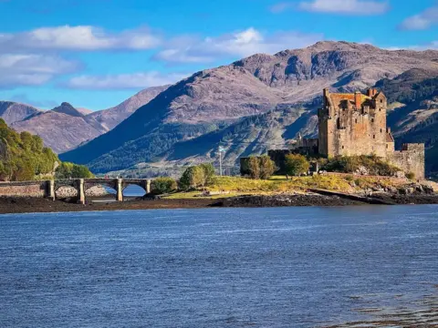 Mark Reynolds A castle with a mountain in the background and a loch in the foreground