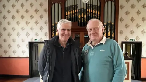 Martin McLachlan and pastoral assistant Paul Wells in front of the organ