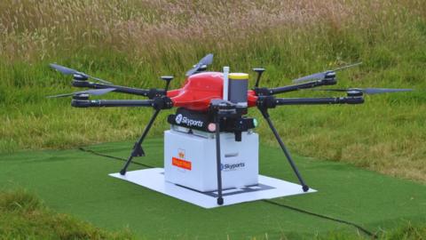 New royal mail drone with package underneath on grass