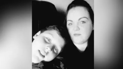 Marrissa Mullans A black-and-white photo of a mum and son. Both have dark hair.