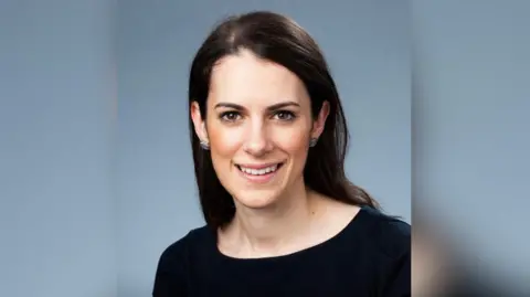 Smartphone Free Childhood Rosalind McClean is wearing a black top. She has long black hair. The background is blue. 