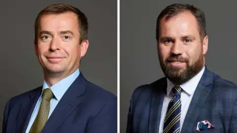 Official portraits of Calum Miller and Sean Woodcock. Both are dressed smartly and are stood in front of a grey background.