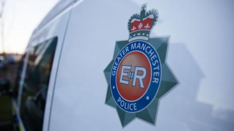 Greater Manchester Police's badge on the side of a white van