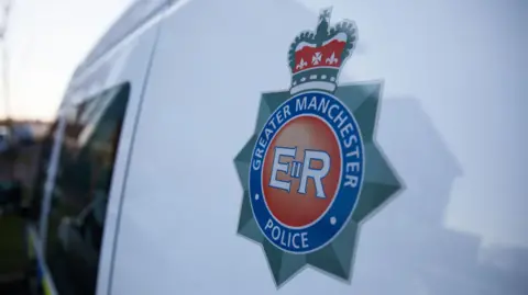 Greater Manchester Police's badge on the side of a white van