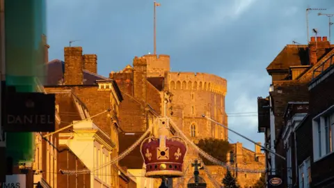 Windsor Castle and royal-themed Christmas decorations are pictured bathed in late afternoon sunlight on 10 December 2021 in Windsor, United Kingdom. 
