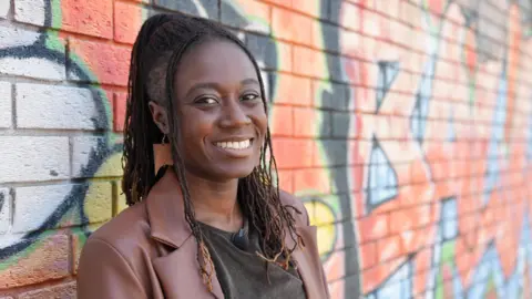 Dawid Wojtowicz/BBC Lavz standing in front of a graffitied wall