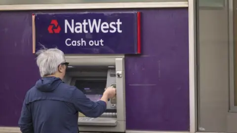 Getty Images Customer using NatWest ATM