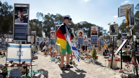 Reuters People visit the site of the Nova festival, where 378 people were killed and dozens were taken hostage by Hamas gunmen on 7 October 2023, near Re'im in southern Israel (7 October 2025)