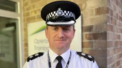 Chief Superintendent Phil Staynings in uniform, smiling outside Wiltshire Police headquarters, Devizes