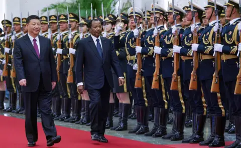 AFP Chinese President Xi Jinping (L) accompanies President of Cameroon Paul Biya (R) to view an honour guard during a welcoming ceremony inside the Great Hall of the People on March 22, 2018 in Beijing, China.