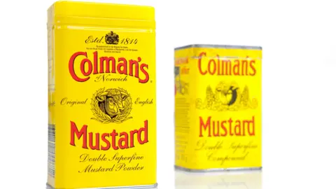 tins of colman's mustard - bright yellow with red writing and trademark insignia